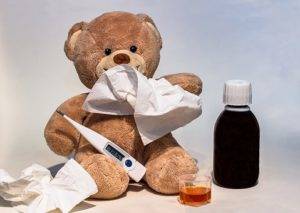 teddy bear holding cold medicine